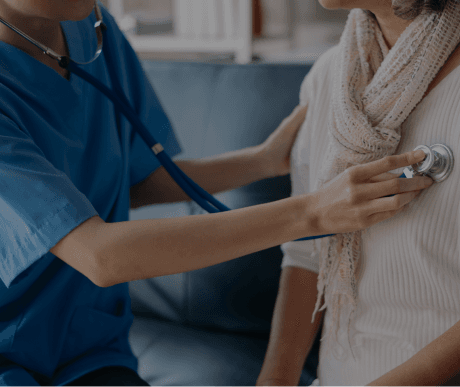 A doctor listens to a patient's heart with a stethoscope during a checkup
